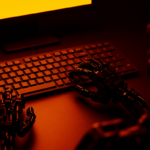 Mãos robóticas digitando em um teclado iluminado pela luz intensa de um monitor, simbolizando a interação entre inteligência artificial e criação humana.