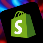 Logo da Shopify exibido na tela de um smartphone com fundo desfocado em tons vibrantes de azul e vermelho, criando um contraste moderno e chamativo.
