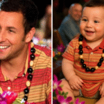 Bebê reborn com traços realistas inspirados em Adam Sandler, usando camisa polo listrada e colar havaiano, sorrindo em meio a uma festa tropical decorada com flores.